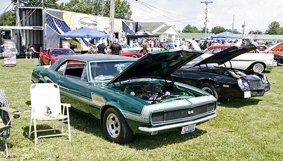 A green first-generation Camaro on display on the show field