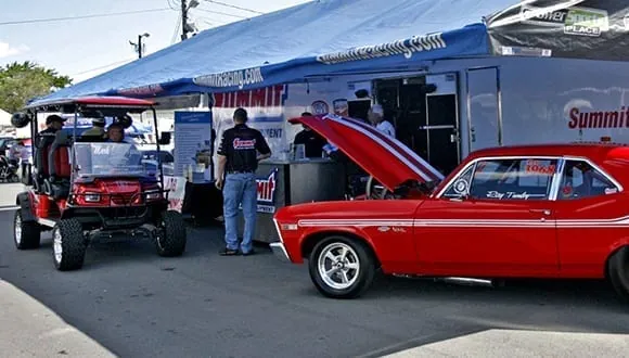 A red classic car at the Summit Racing display